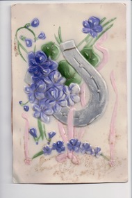 Plastic postcard showing purple flowers and lucky horseshoe with paper backing 