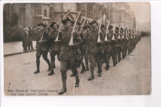 Postcard depicting image of armed soldiers marching in formation along street