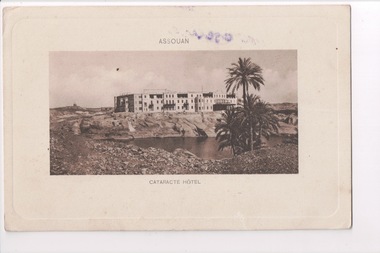 Postcard depicting image of large rectangular building with lake and palm tree