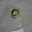 Small gold coloured metal button embossed with crown and map of Australia with loop fitting at rear.