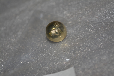 Small gold coloured metal button embossed with crown and map of Australia with loop fitting at rear.