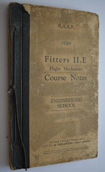 Book has black binding with black cord to bind it. Cover is a dirty cream colour with black writing. 