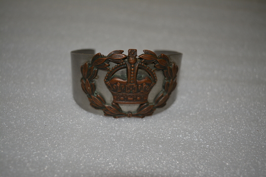 Handmade silver metal bracelet overlaid with brass crown encircled by laurel