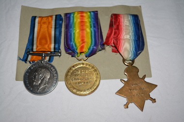 Two round and one star shaped medals with ribbons attached 