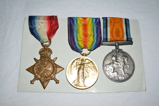 round silver coloured metal medal with grey black white and orange striped ribbon -
round gold coloured metal medal with purple blue green yellow and orange striped ribbon and
bronze coloured star shaped metal medal with blue white and red striped ribbon