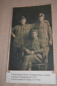 Reproduction copy of black and white portrait of three uniformed men two standing and one seated in front.
