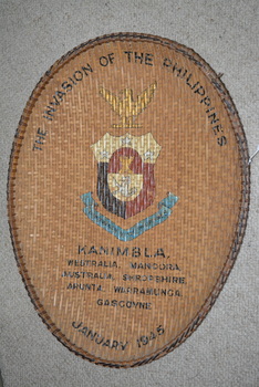 Large oval shaped cane woven basket tray with colour print of emblem in centre
