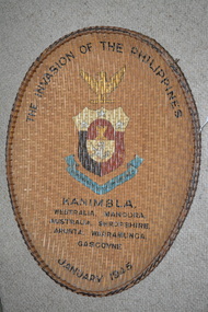 Large oval shaped cane woven basket tray with colour print of emblem in centre