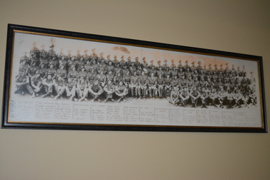 Black and white reproduction copy of battalion of soldiers with list of names below