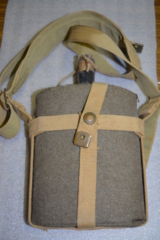 Felt covered metal water bottle with attached cork stopper and canvas straps.