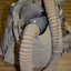 Canvas bag containing Small Box Respirator consisting of a rubberised fabric face mask, connected by a fabric covered rubber hose to a canister made of tin plate.