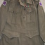 Khaki woollen jacket with shoulder epaulettes and four pockets with brass buttons attached.  