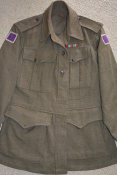 Khaki woollen jacket with shoulder epaulettes and four pockets with brass buttons attached.  