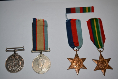 Two round silver metal and two brass star shaped medals. Three medals have coloured ribbons attached.