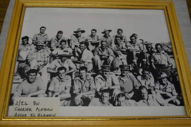 Four rows of soldiers mostly sitting down whilst photo taken