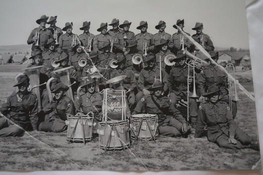 Reproduced black and white photograph of band of soldiers with musical instruments in the field