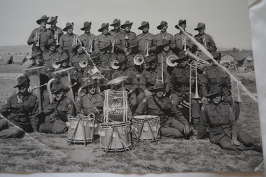 Reproduced black and white photograph of band of soldiers with musical instruments in the field