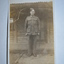 Black and white photograph  of soldier standing in front of weatherboard house