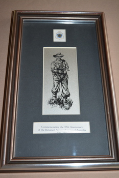 Silver plate frame with black mount containing sketch of soldier holding automatic rifle