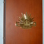 Timber look laminate box  with gold colour metal "rising sun" badge on front.  The box opens out flat and contains seven metal " rising sun " badges mounted on black felt on the right side.