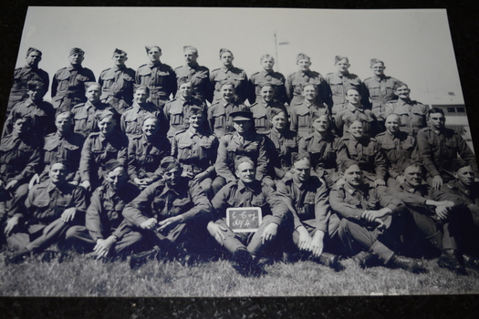 black and white photograph depicting two rows of soldiers standing and two rows sitting