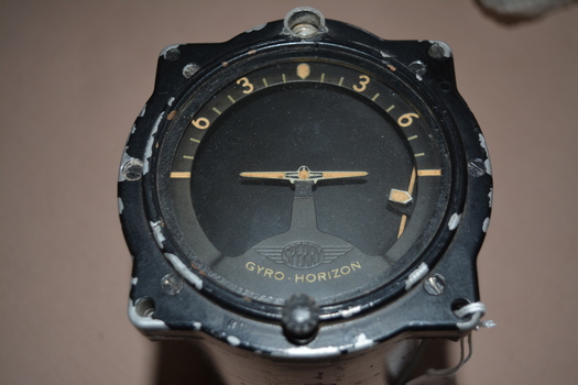  Black painted cylindrical instrument with side cutout containing moving metal parts inserted with glass at one end.