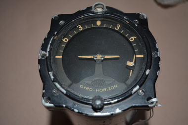  Black painted cylindrical instrument with side cutout containing moving metal parts inserted with glass at one end.