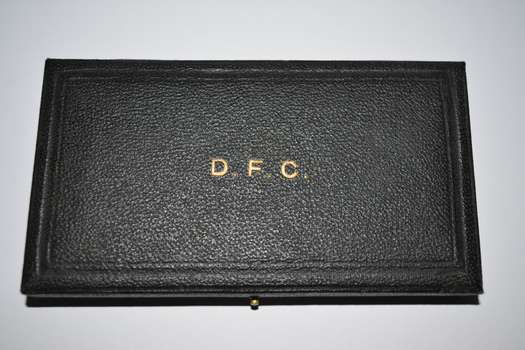 Black case which opens out from right side.  The top affixed by two side hinges on the left and push in pin on the right side.   