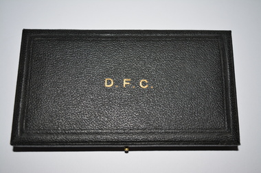 Black case which opens out from right side.  The top affixed by two side hinges on the left and push in pin on the right side.   