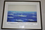 Black frame with cream mount containing a screen print on silk depicting 9 naval ships and 4 airborne aircraft at sea  