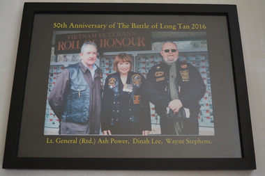 photograph of two males either side of female - wearing jackets with colour badges/patches.