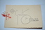 Folded cream cardboard with irregular edging with wording in black print on front cover and inside back cover.  