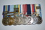 Set of eight metal medals with multi coloured stripped ribbons attached. 