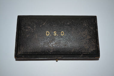 Small rectangular black leather look covered timber box with DSO stamped on lid.