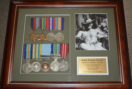 Two star and eight round shaped medals all attached to various striped ribbons framed together with photograph and plaque
