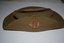 Khaki felt hat with rising star badge attached to brim turned up on right side.