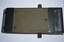 Rectangular shaped black and green metal object with sloping ends containing glass. Black metal handle at front with small black knobs attached to both sides.