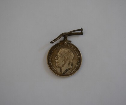 Round white metal medal with bent bar attachment