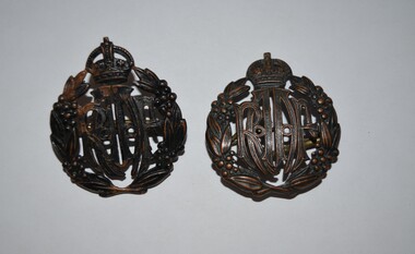 Cast metal cap badge with pierced design - RAAF at centre, surrounded by wattle wreath and surmounted with a crown.