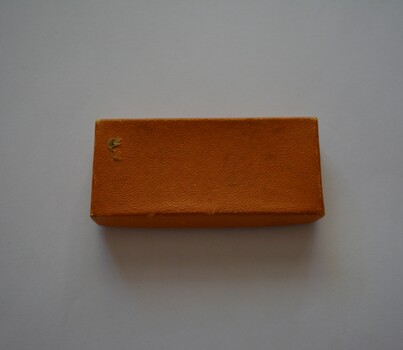  Small oblong shaped box with lid covered in tan colour paper containing newspaper cuttings