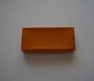  Small oblong shaped box with lid covered in tan colour paper containing newspaper cuttings