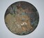 Round bronze plaque includes an image of Britannia holding a trident and standing with a lion with name of deceased soldier on right side.