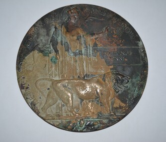 Round bronze plaque includes an image of Britannia holding a trident and standing with a lion with name of deceased soldier on right side.