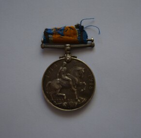 Round silver metal medal with remnants of blue and orange ribbon on attached clasp suspender bar. 