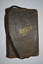 Black leather-bound covered booklet with black ribbon attached.