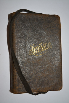 Black leather-bound covered booklet with black ribbon attached.