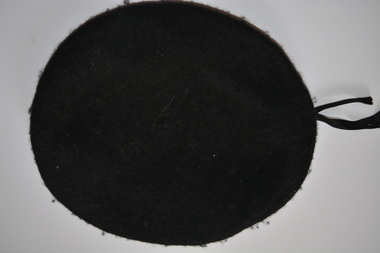 Black wool with leather trim and ribbon beret with white metal badge of coat of arms attached