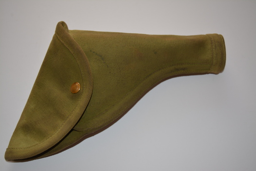 Green khaki canvas holster with flap secured by metal fastener. Three brass belt clips attached at back.