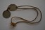 Length of cord with two silver metal discs attached.