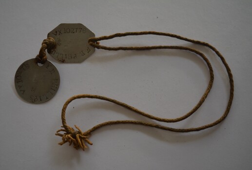 Length of cord with two silver metal discs attached.